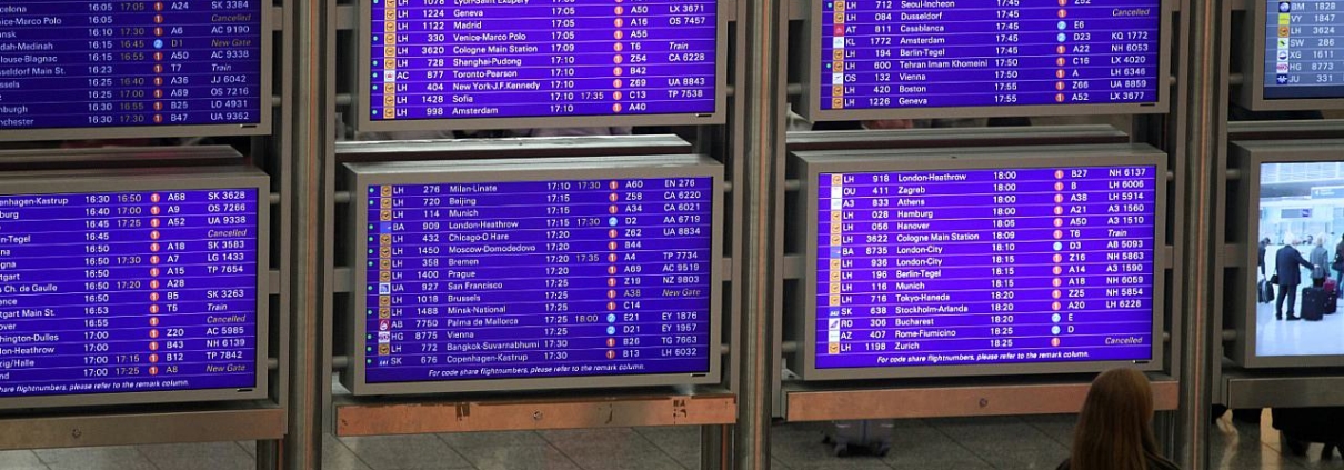 Frau vor Informationstafel am Frankfurter Flughafen