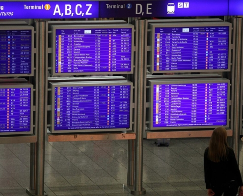 Frau vor Informationstafel am Frankfurter Flughafen